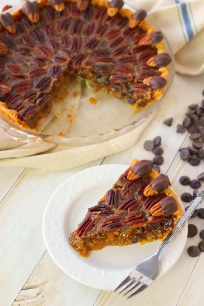 Your favorite pie recipe made even more decadent and delicious! Dark chocolate is added to this pecan pie recipe and topped with chocolate covered pecans for a show-stopping dessert! This pie is perfect for your Thanksgiving or Christmas dessert table!