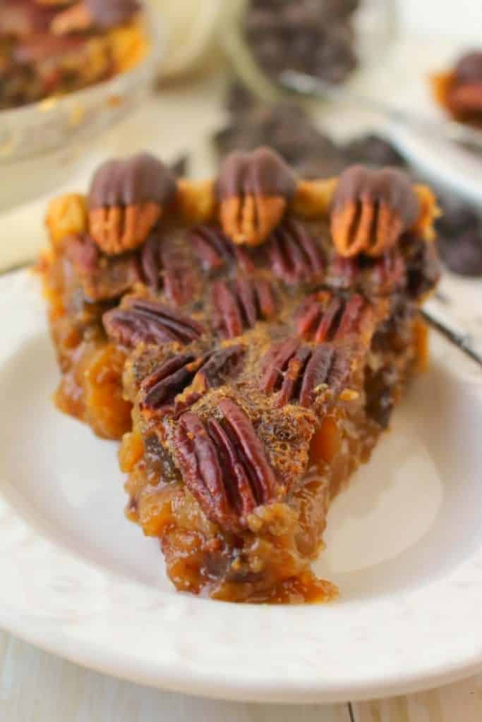 Your favorite pie recipe made even more decadent and delicious!  This Dark Chocolate Pecan Pie recipe is topped with chocolate covered pecans for a show-stopping dessert and is perfect for your Thanksgiving or Christmas dessert table!