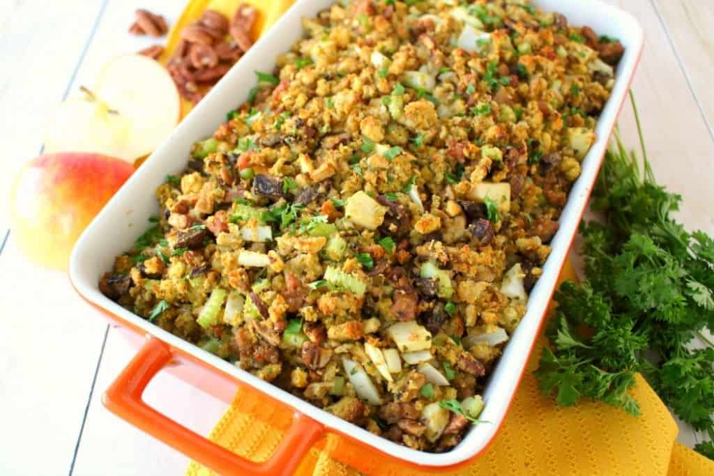 This Thanksgiving stuffing recipe will be an instant holiday dinner favorite with everyone at the table!  Loaded with apples, sausage, mushrooms, pecans and more, this dressing is the ultimate side dish for your holiday meal! Can be made in the oven or slow cooker!