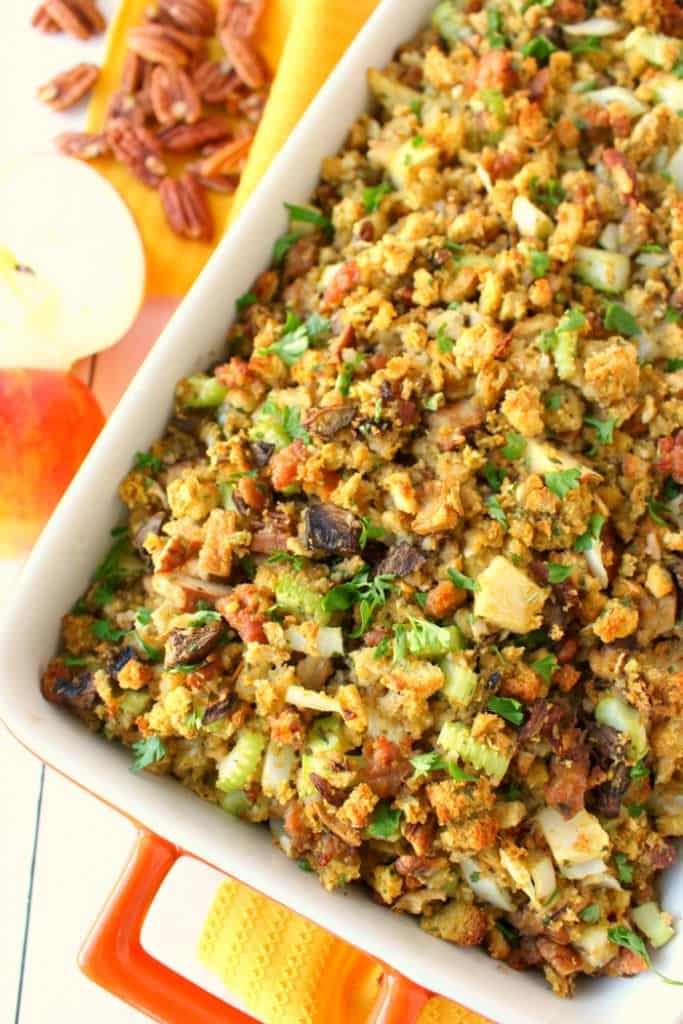 This Thanksgiving stuffing recipe will be an instant holiday dinner favorite with everyone at the table!  Loaded with apples, sausage, mushrooms, pecans and more, this dressing is the ultimate side dish for your holiday meal! Can be made in the oven or slow cooker!