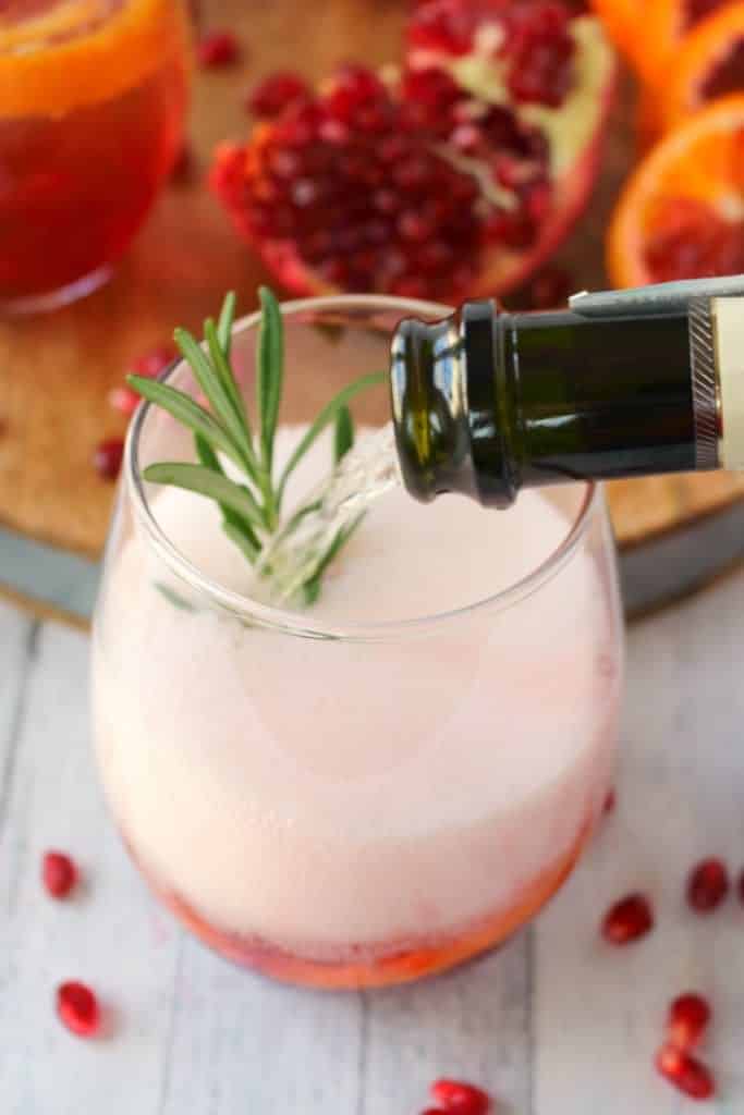 Want a delicious, classy cocktail that everyone at your holiday party will love? My Pomegranate Citrus Champagne Cocktail is made with sweet blood orange slices, pomegranate juice and seeds, citrus vodka and topped with Champagne. This libation is perfect for Thanksgiving, Christmas, New Years and fantastic for brunch, too!