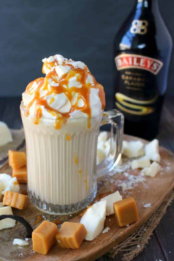 If you're a fan of Rum Chata or Bailey's, you're gonna LOVE this Spiked White Hot Chocolate! Homemade hot chocolate made with just a few simple ingredients, this hot cocktail is perfect for a chilly night in! Topped with whipped cream, white chocolate chunks and caramel this drink is decadent and delicious!
