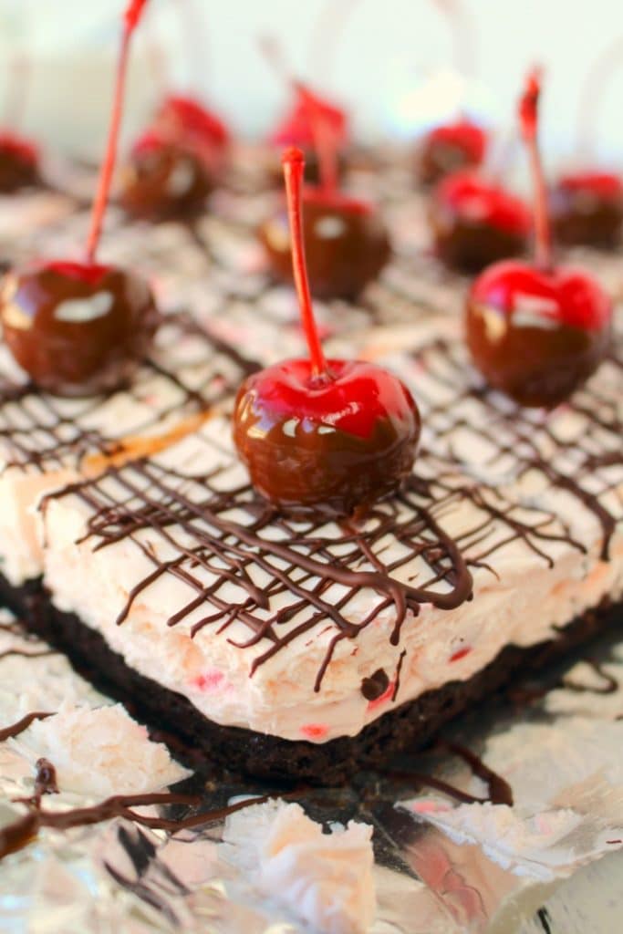 No bake cheesecake bars don't get better than this! Made with an OREO crust, a creamy no bake cherry cheesecake filling, and topped with a chocolate drizzle and chocolate dipped cherries, these bars are incredible. Easy to make, and completely delicious!