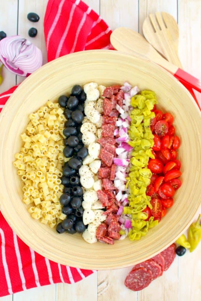 If you love Italian anitpasto, then this chopped salad recipe will be right up your alley! Loaded with fresh romaine lettuce, mozzarella, olives, salami and more, this incredible anitpasto salad will quickly become a family favorite for every potluck, cookout, and picnic this summer. Even better than the famous Olive Garden salad!