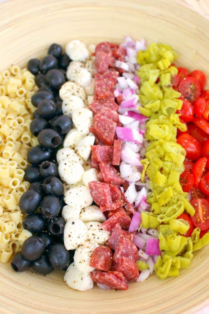 If you love Italian anitpasto, then this chopped salad recipe will be right up your alley! Loaded with fresh romaine lettuce, mozzarella, olives, salami and more, this incredible anitpasto salad will quickly become a family favorite for every potluck, cookout, and picnic this summer. Even better than the famous Olive Garden salad!