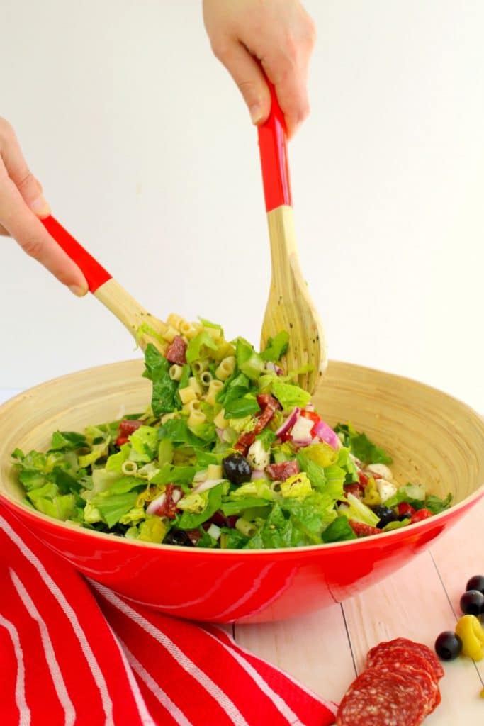 If you love Italian anitpasto, then this chopped salad recipe will be right up your alley! Loaded with fresh romaine lettuce, mozzarella, olives, salami and more, this incredible anitpasto salad will quickly become a family favorite for every potluck, cookout, and picnic this summer. Even better than the famous Olive Garden salad!