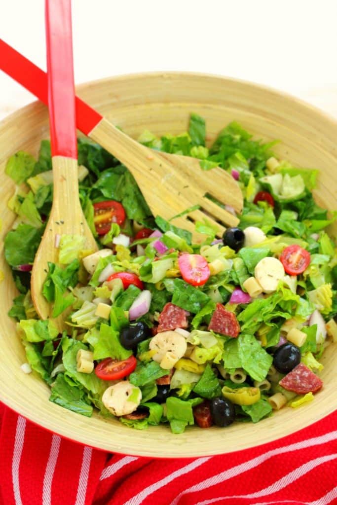 If you love Italian anitpasto, then this chopped salad recipe will be right up your alley! Loaded with fresh romaine lettuce, mozzarella, olives, salami and more, this incredible anitpasto salad will quickly become a family favorite for every potluck, cookout, and picnic this summer. Even better than the famous Olive Garden salad!