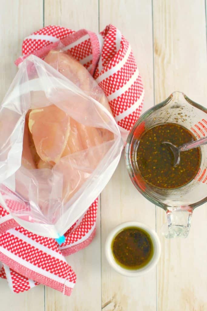 Balsamic marinade with chicken in ziploc bag ready to marinate grilled caprese chicken.