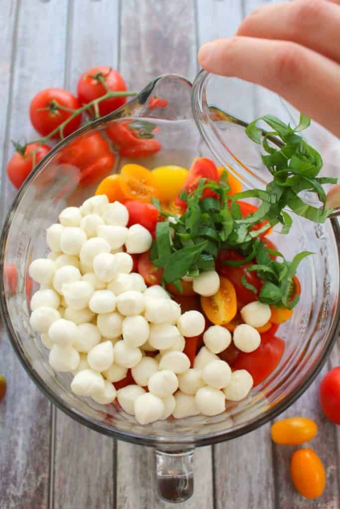 With just 6 ingredients, this simple tomato salad recipe will be your new go-to summer side!  Made with fresh cherry tomatoes, mozzarella, basil and a 3 ingredient balsamic vinaigrette, this caprese salad takes just minutes to make and tastes incredible!