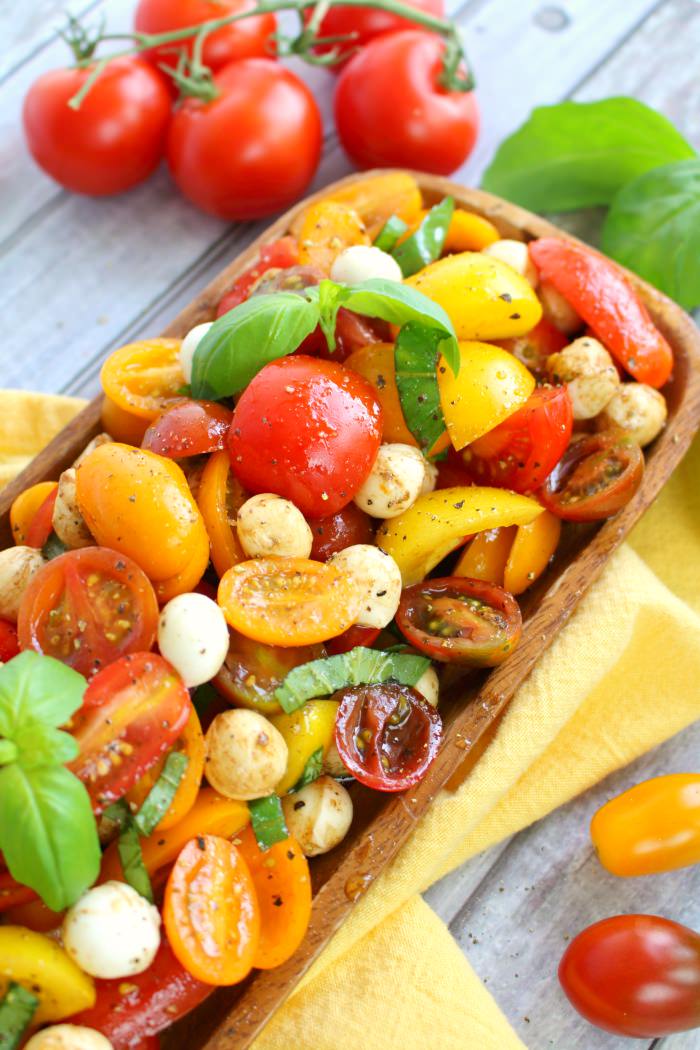 With just 6 ingredients, this simple tomato salad recipe will be your new go-to summer side!  Made with fresh cherry tomatoes, mozzarella, basil and a 3 ingredient balsamic vinaigrette, this caprese salad takes just minutes to make and tastes incredible!