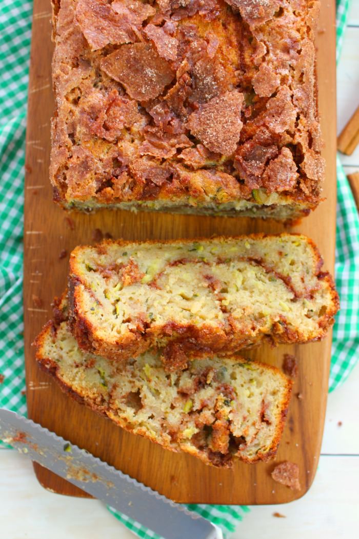 Cinnamon swirl zucchini bread on board, with two slices on their side.