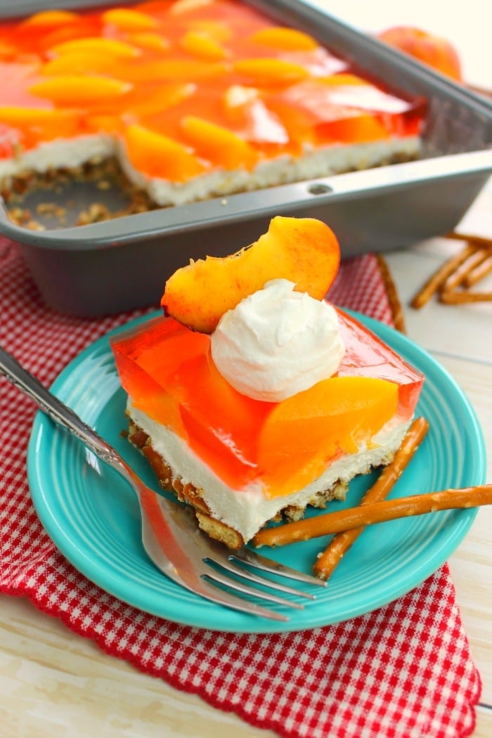 If you love the classic strawberry version, then this peach pretzel salad recipe is right up your alley! Made with a salty-sweet pretzel crust, a delicious cream cheese filling, and an amazing layer of peaches this jello pretzel salad is perfect for your next potluck, cookout or picnic.