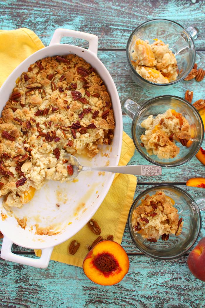 Cake mix peach cobbler with three bowls of cobbler on the side.