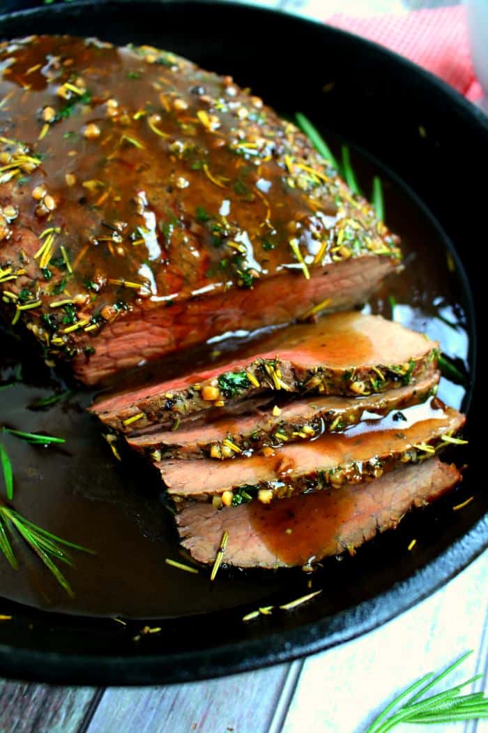 This Garlic Herb Roast Beef is fancy enough for your Christmas dinner, and simple enough for a Sunday supper. Oven roasted with a garlic herb rub, and topped with an amazing red wine sauce, this roast beef recipe is one you'll make all year long!