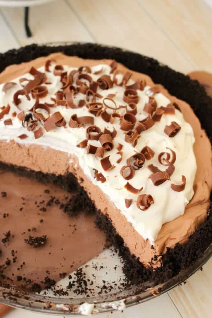 A chocolate mouse pie recipe topped with whipped cream and chocolate curls.
