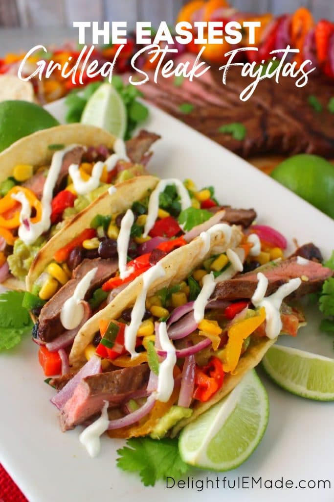 Grilled steak fajitas and flank steak fajita marinade on platter with lime wedges.