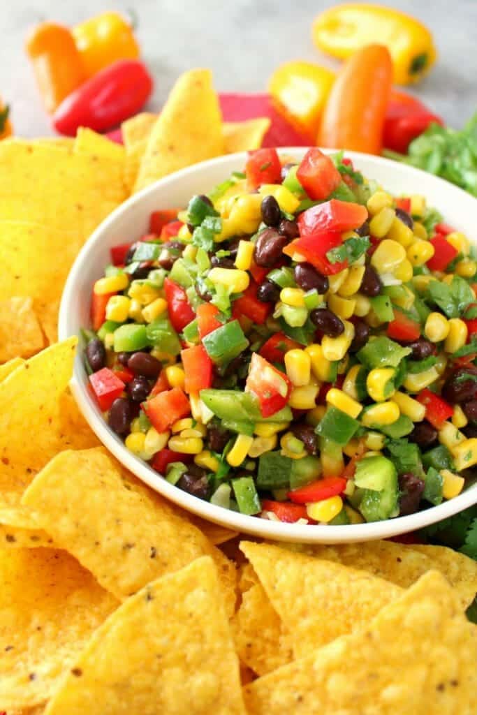Perfect with your favorite tortilla chips, this delicious Southwestern Corn Salsa is amazing! Loaded with fresh, delicious veggies, this easy salsa recipe is just as flavorful as it is pretty. Fantastic as an easy appetizer for game day, and perfect for Cinco de Mayo!
