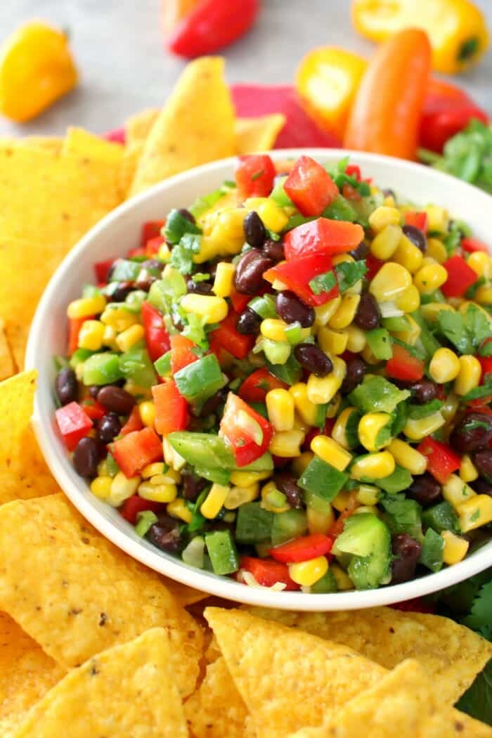 Perfect with your favorite tortilla chips, this delicious Southwestern Corn Salsa is amazing! Loaded with fresh, delicious veggies, this easy salsa recipe is just as flavorful as it is pretty. Fantastic as an easy appetizer for game day, and perfect for Cinco de Mayo!