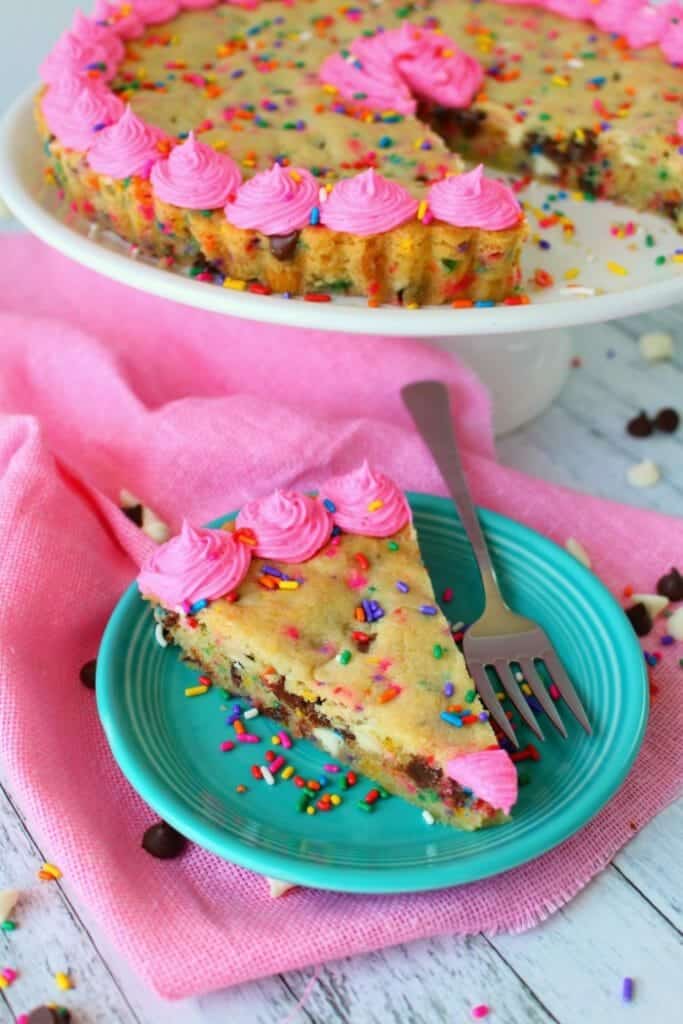 This Funfetti Giant Chocolate Chip Cookie Cake has party written all over it! Make with lots of rainbow sprinkles, white and semi-sweet chocolate chips and topped with a delicious buttercream frosting, this giant cookie is perfect for a birthday party or celebration!