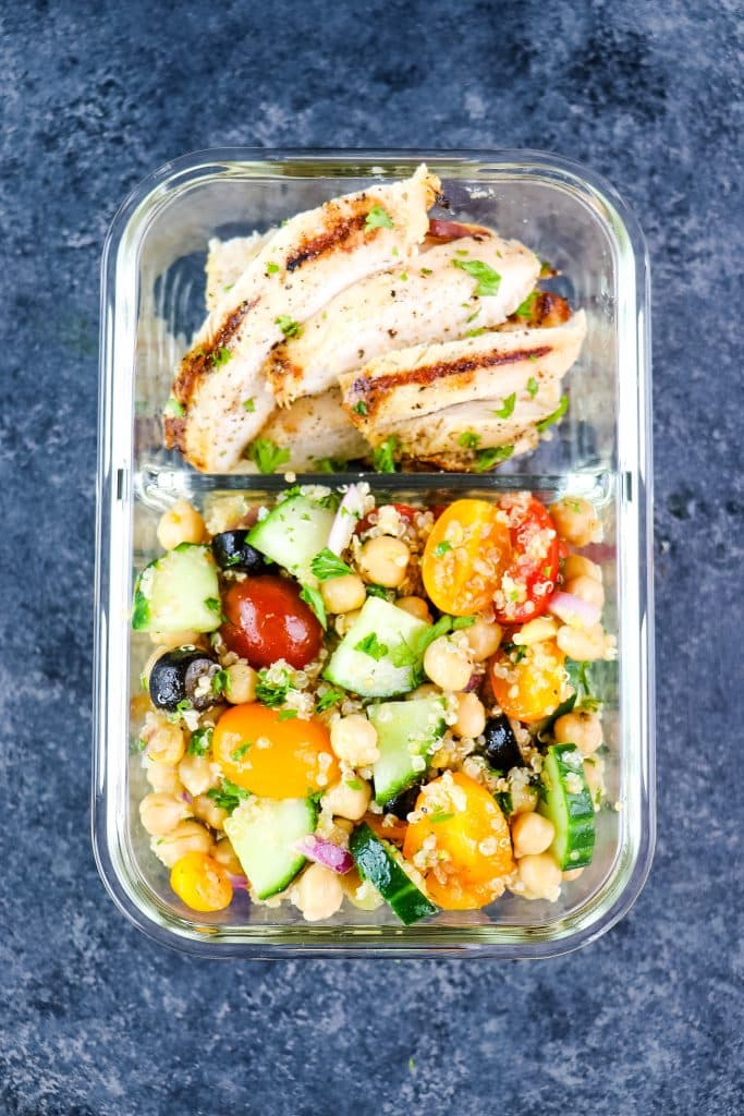 Meal prep container with lemon pepper grilled chicken and quinoa salad.