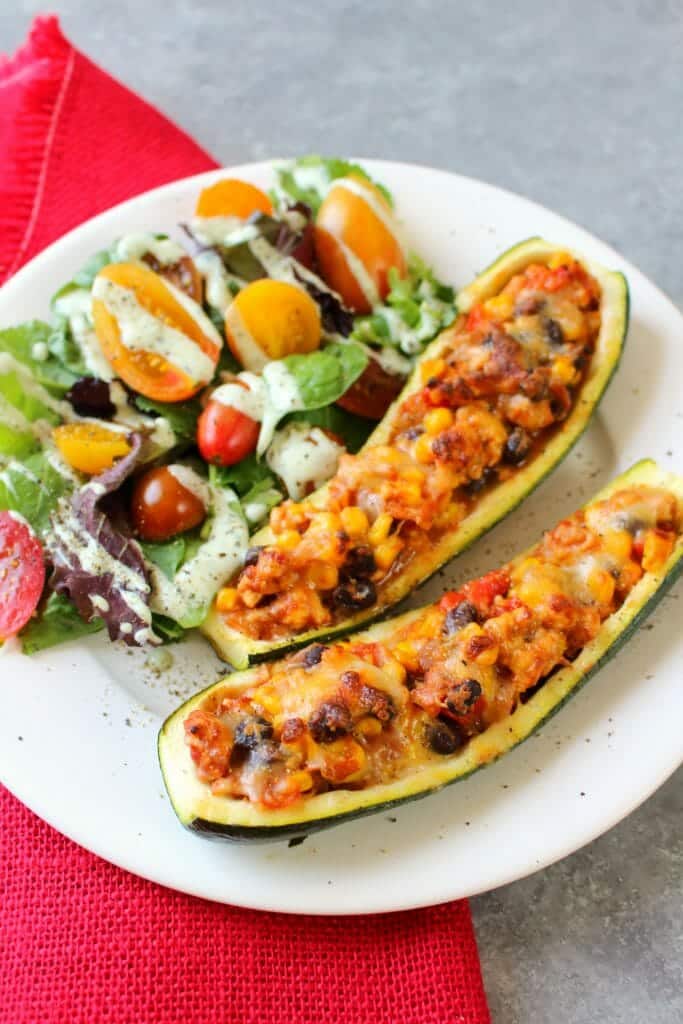 Looking for a healthy, low-carb dinner idea that actually tastes good? These Taco Stuffed Zucchini Boats are made with lean ground turkey filling along with peppers, onions, beans and corn. Loaded with flavor, these stuffed zucchini are the perfect healthy dinner!