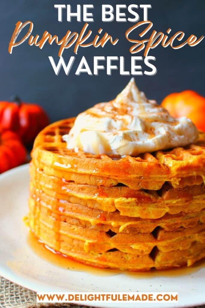 Stack of pumpkin waffles topped with whipped cream and maple syrup.