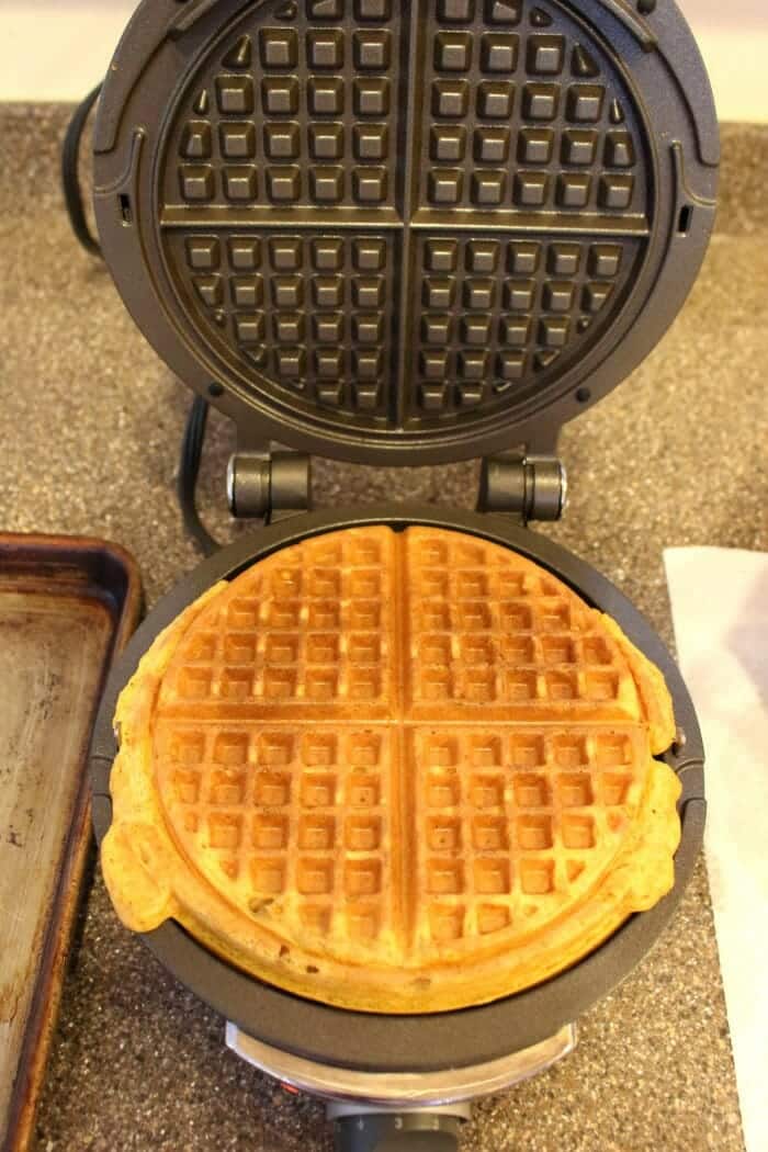 Pumpkin spice waffle on waffle iron, after cooking.