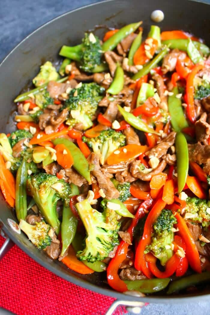 Vegetable Beef Stir Fry in skillet topped with peanuts.