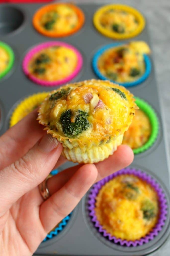 Healthy baked egg muffins, one muffin held in hand.