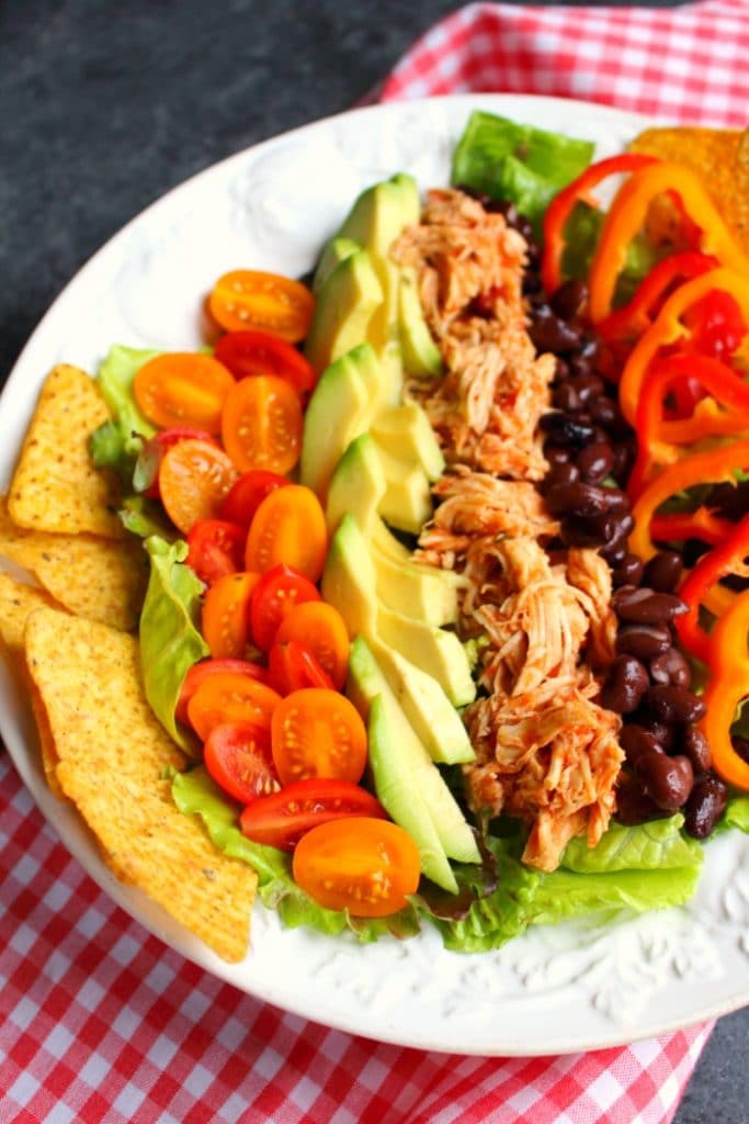 This simple Chicken Taco Salad recipe is the perfect healthy lunch for packing and taking to work! Loaded with savory shredded chicken, black beans and veggies, this taco salad will be your new favorite way to pack your lunch!