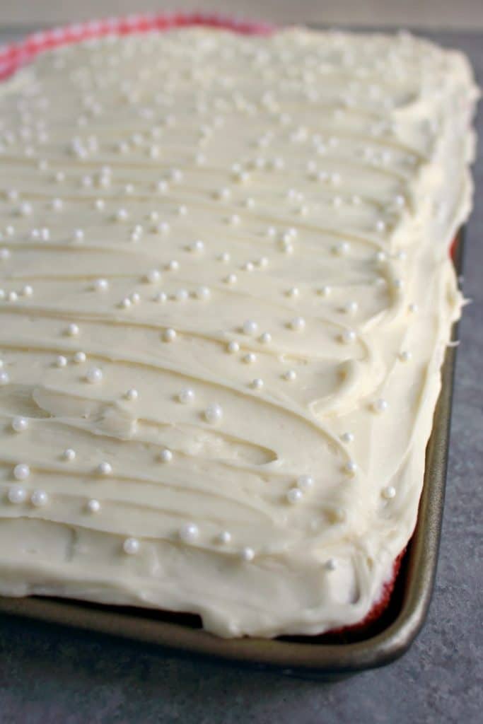 This scrumptious Red Velvet Sheet Cake recipe will be your new favorite way to do cake! Topped with a thick, delicious layer of cream cheese frosting, this easy red velvet cake recipe is incredible!