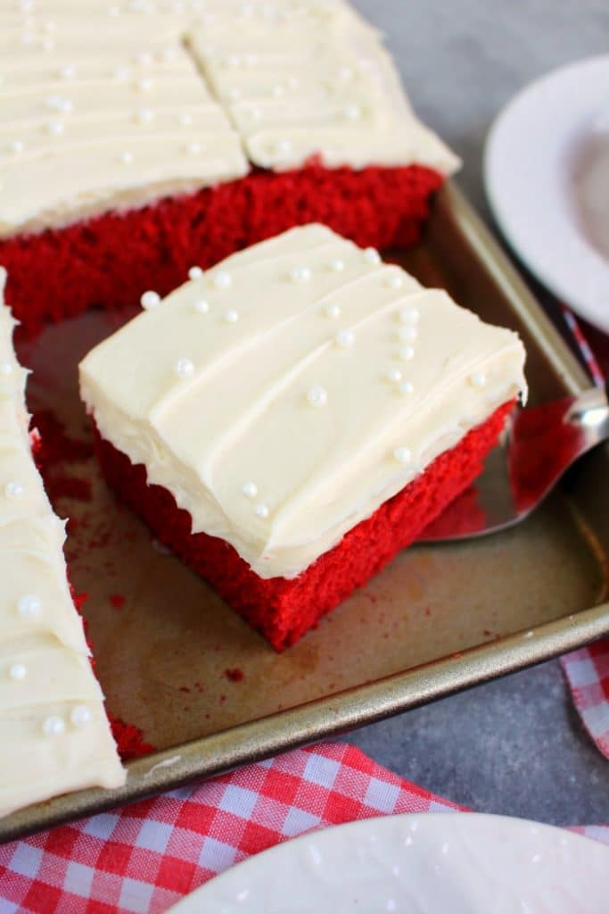 This scrumptious Red Velvet Sheet Cake recipe will be your new favorite way to do cake! Topped with a thick, delicious layer of cream cheese frosting, this homemade sheet cake recipe is incredible!
