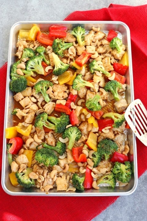 This Healthy Cashew Chicken recipe will be your new favorite weeknight dinner idea. Simply made, this sheet pan dinner idea is loaded with veggies and an amazing sauce.