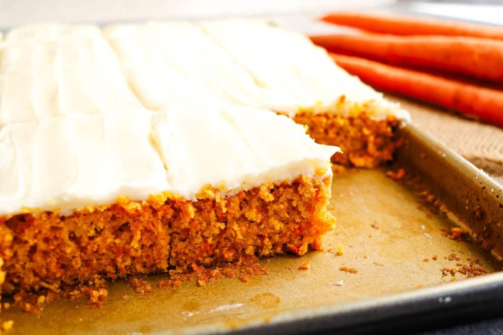 Carrot cake sheet cake cut into squares in the pan.