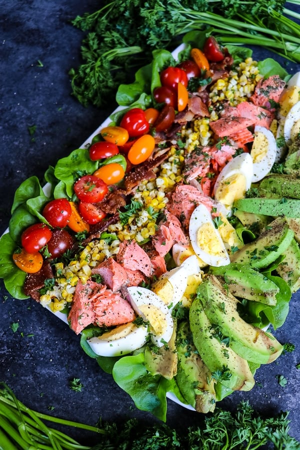 This Salmon Cobb Salad Recipe will be your new favorite way to enjoy a healthy lunch! Made with grilled salmon, avocados, hard-boiled eggs and more, this Grilled Salmon Salad is the perfect meal prep salad idea! 