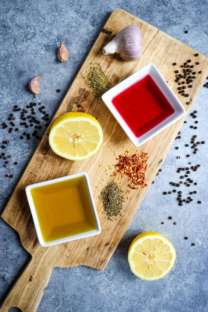 Ingredients to make an Italian chicken marinade on a board.