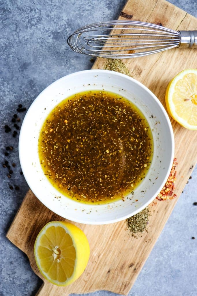 Bowl of Italian marinade with lemon and olive oil for marinating chicken.