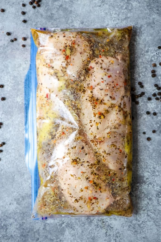 Chicken breasts in a zip lock bag with chicken breasts being marinated.