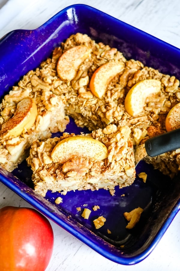 Apple Cinnamon Baked oatmeal, cut into slices with one slice offset and topped with apple slices.