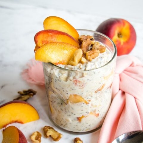 Peach overnight oats topped with walnuts and peach slices.
