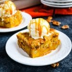 slice of pumpkin dump cake topped with vanilla ice cream and caramel drizzle.