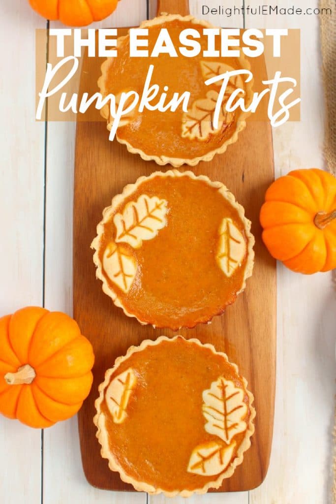 Pumpkin tarts on board garnished with mini pumpkins.