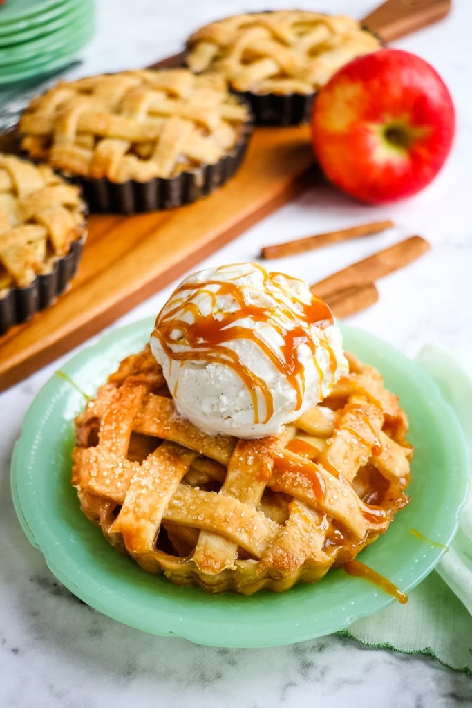 Apple pie tarts topped with ice cream and caramel sauce.