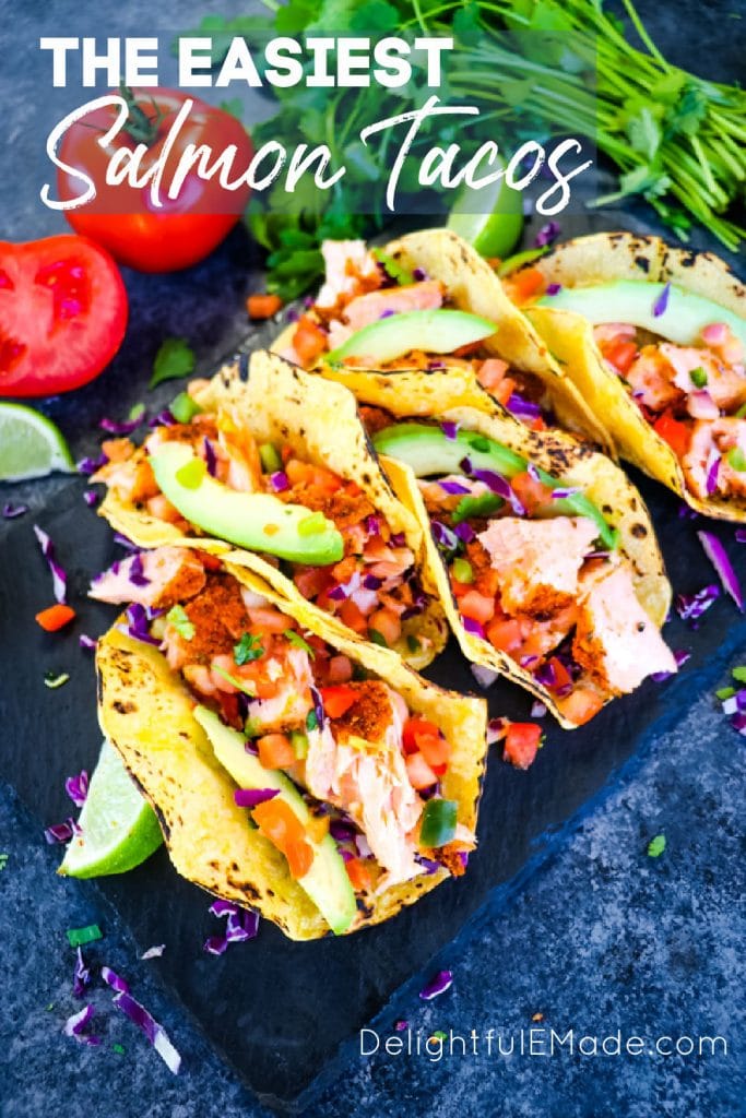 Salmon Tacos recipe on board with cilantro, avocado salsa.