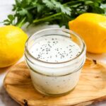 Creamy poppy seed dressing recipe in small mason jar with lemons.