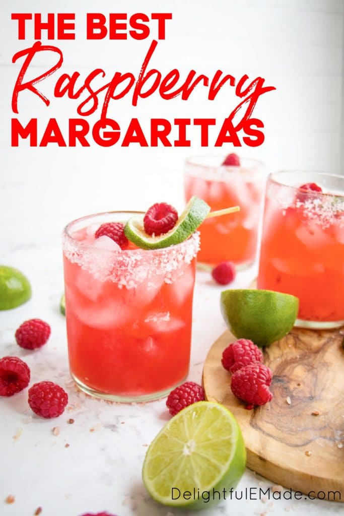 Raspberry margarita on the rocks with fresh raspberries and lime slices.