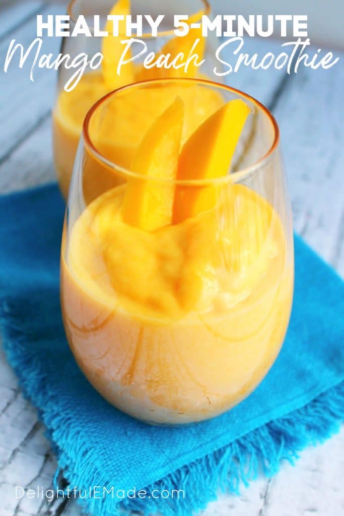 Mango peach smoothie recipe in two glasses topped with slices of fresh mango.