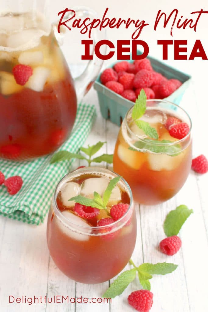 Glasses and pitcher of raspberry mint iced tea, with fresh raspberries and mint sprigs.