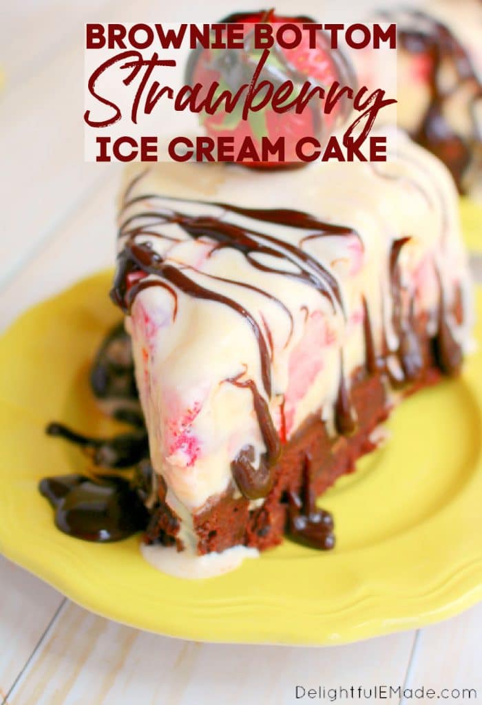 Slice of strawberry ice cream cake drizzled with hot fudge, on plate.