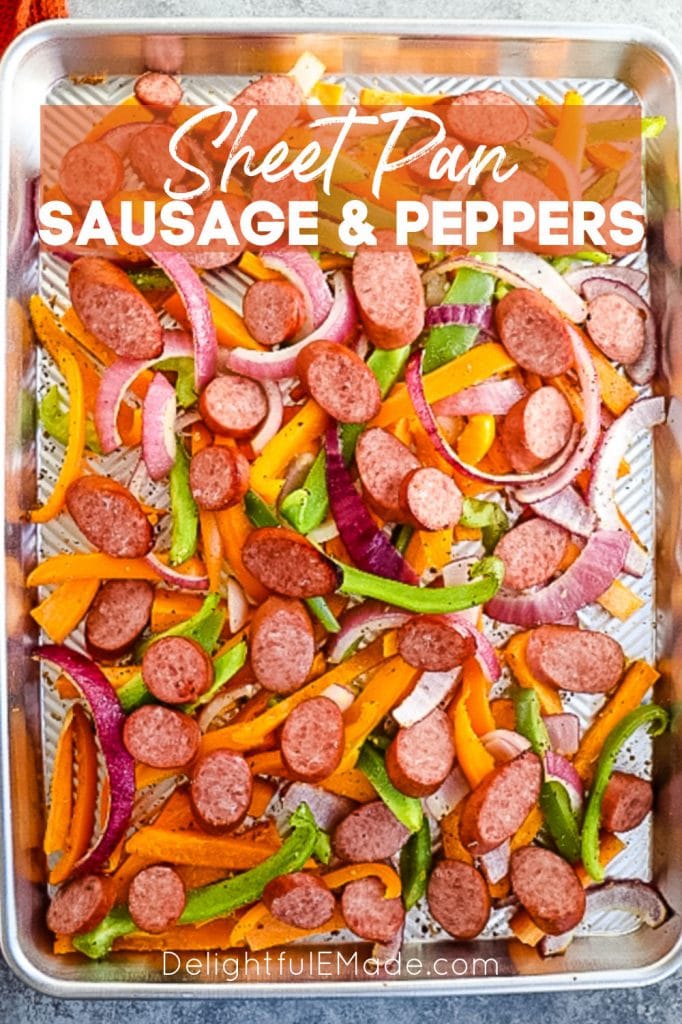 Sheet pan sausage and peppers with sweet potatoes on a baking sheet.